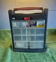 Front view showing 15 clear compartments, red latch and carry handle