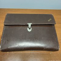 Closed leather case front view showing clasp and monogram