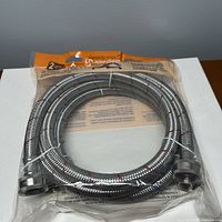 Front view of sealed package showing coiled braided stainless steel hoses