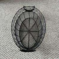 Top view of black metal wire oval basket showing scroll rim and mesh base