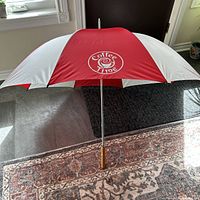 Top view of opened umbrella showing red and white canopy and Coffee Time logo