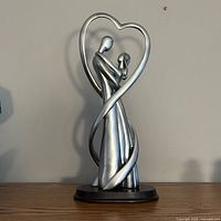 Full view of silver resin couple figurine on black base