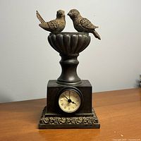 Full view of mantel clock showing birds, urn, base, and dial