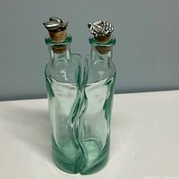 Front view of both nesting bottles with metal-topped corks