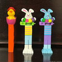 Front view of three PEZ dispensers showing characters and colours