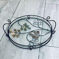 Full view of round metal and glass tray showing handles and leaf motif