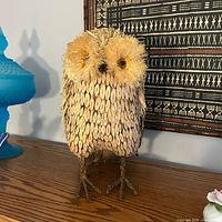 Full view of owl figurine standing on shelf
