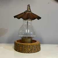 Full view of bird feeder showing metal roof, glass globe, wood base