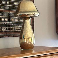 Full view of silvered glass mushroom figure on surface