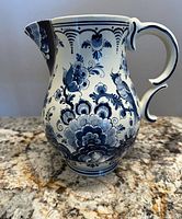 Full view of Delft blue milk jug showing floral motifs and handle