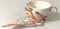Cup resting on saucer showing butterfly wing handle detail