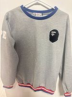 Front view displaying logo patch, sleeve print, collar, and hem details