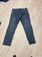 Front view of full pair of jeans laid flat