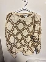 Front view of cream and brown geometric chunky knit sweater on hanger