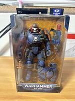 Front view showing sealed figure, accessories and branding