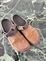 Top view showing pair of brown Crocs clogs with suede-look upper and straps
