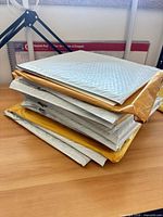 Stack of about seven padded envelopes presumed to contain press kits