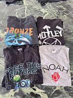 Group shot of all four folded T-shirts