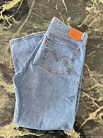 Full view folded Levi’s jeans showing back pocket and overall color