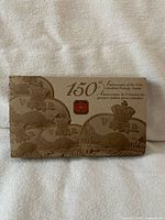 Closed presentation box showing anniversary graphics and Royal Canadian Mint sticker