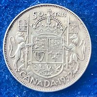 Reverse of 1952 Canadian 50 cent coin showing coat of arms and denomination
