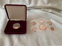 Overview of both coin items: cased 1982 proof dollar and 1970 six-coin set in plastic