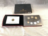 Presentation case open showing six coins and certificate card