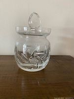 Full view of covered crystal dish on wood surface