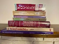 Stack of eight antiques reference books on shelf