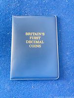 Front of closed blue wallet with gold title