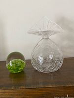 Vase and paperweight side by side on table