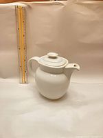 Teapot beside ruler showing height ~20 cm