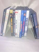 All 11 DVD cases standing upright showing spines and titles