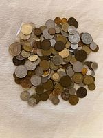 Pile of assorted foreign coins spread on cloth