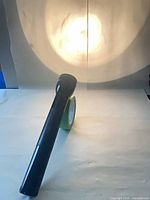 Flashlight powered on projecting beam onto backdrop