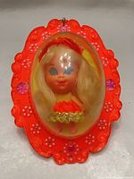 Front view of locket showing doll inside and ornate details