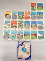 Group view of boxed pendant, pin and pavilion stamp sheet