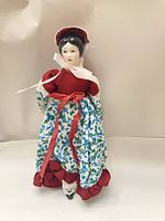 Full frontal standing view of porcelain doll showing costume details