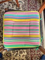 single cushion on chair showing striped pattern, yellow piping, tufting
