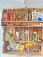 Open tackle box showing two trays filled with various lures and tackle