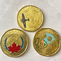 Group shot of three colourized Canadian $1 coins showing reverse designs