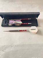 Open case displaying two assembled darts; third dart placed in front to show full profile