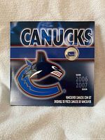 Front of packaged Vancouver Canucks coin set showing team graphics and season year 2006-2007