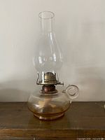 Front view of glass finger oil lamp with chimney attached