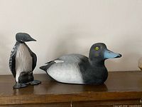 Loon and duck carvings side by side on shelf