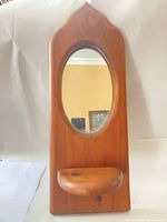 Full view of wooden wall mirror with shelf