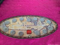 Full view of oval display board with all 12 coins and central red square visible