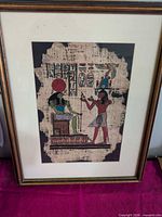 Full view of framed papyrus artwork showing frame, mat and painted scene