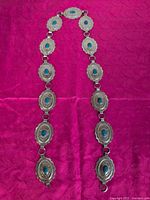 Full view of concho belt laid out showing all linked conchos and turquoise stones