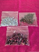 All three bags of assorted natural stone beads on pink fabric background